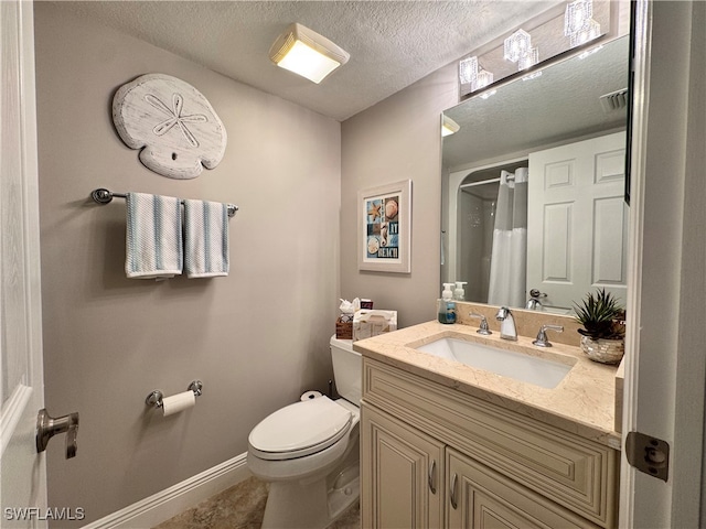 bathroom with vanity, toilet, and a textured ceiling