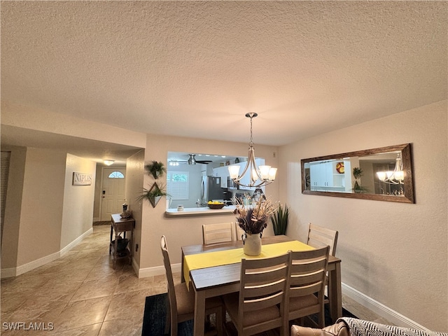 dining area with an inviting chandelier, a textured ceiling, and light tile patterned floors