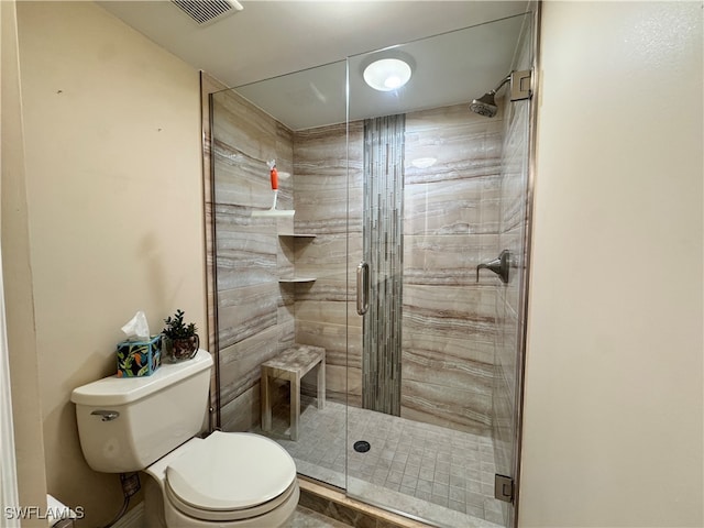 bathroom with a shower with door and toilet