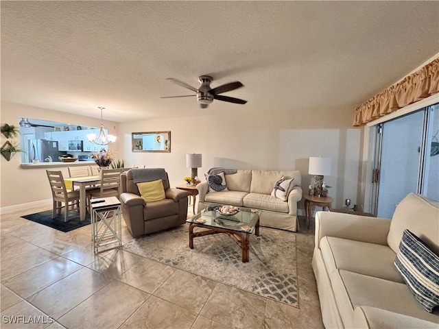 living room featuring tile patterned flooring, ceiling fan with notable chandelier, and a textured ceiling