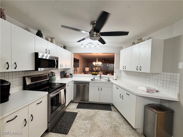 kitchen with white cabinets, sink, tasteful backsplash, a textured ceiling, and stainless steel appliances