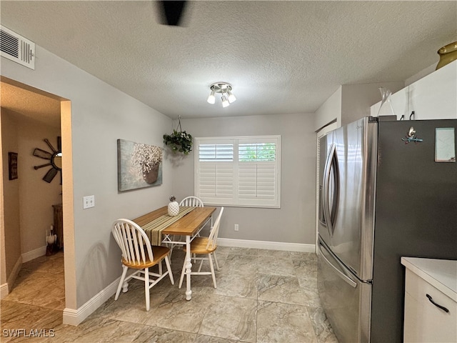 dining space with a textured ceiling