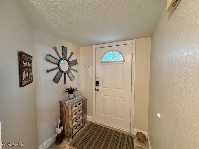 entryway with a textured ceiling