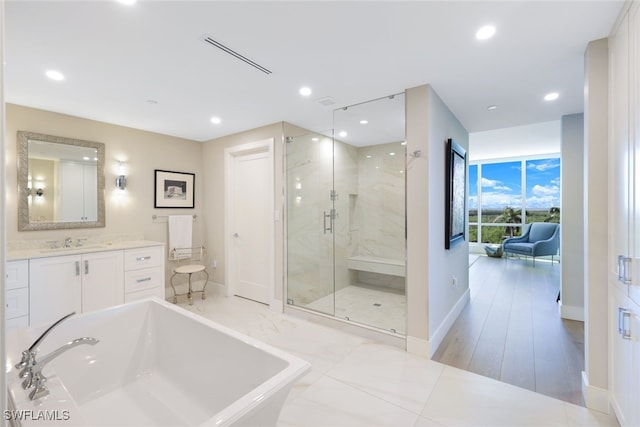 bathroom featuring vanity, wood-type flooring, and plus walk in shower