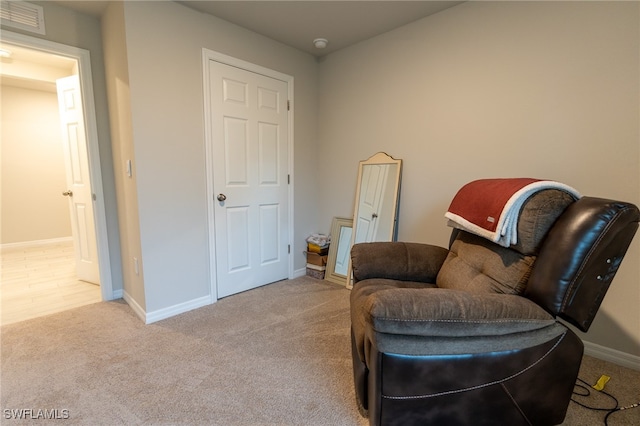 living area featuring light carpet