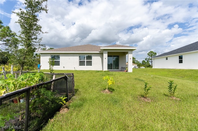 back of house featuring a lawn