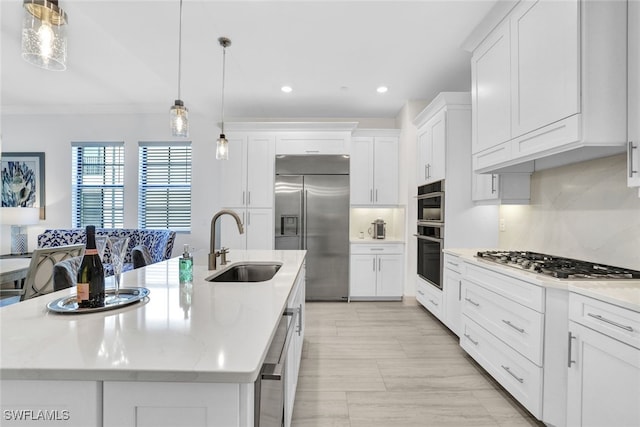 kitchen featuring hanging light fixtures, a center island with sink, stainless steel appliances, and sink