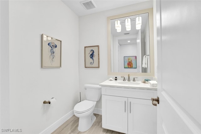 bathroom with hardwood / wood-style floors, vanity, and toilet