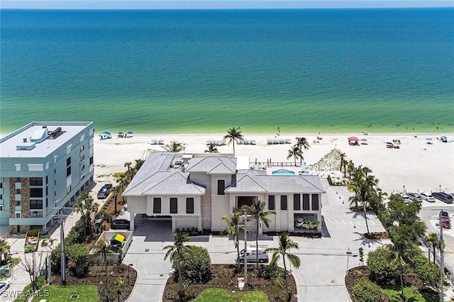 drone / aerial view featuring a water view and a beach view