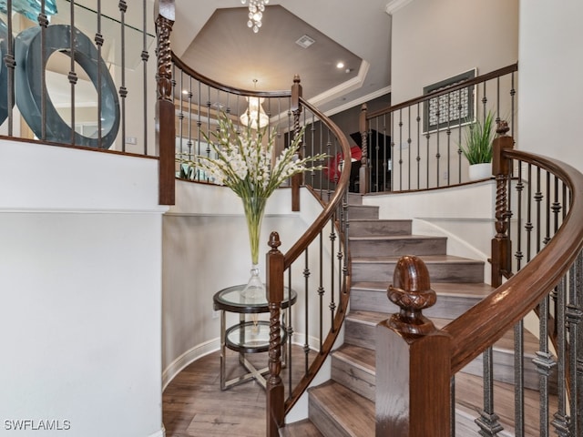 staircase featuring crown molding and hardwood / wood-style flooring