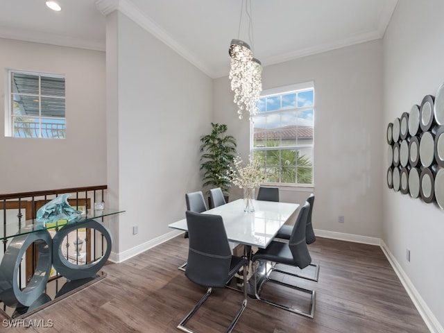 dining area with dark wood-type flooring, crown molding, and a chandelier