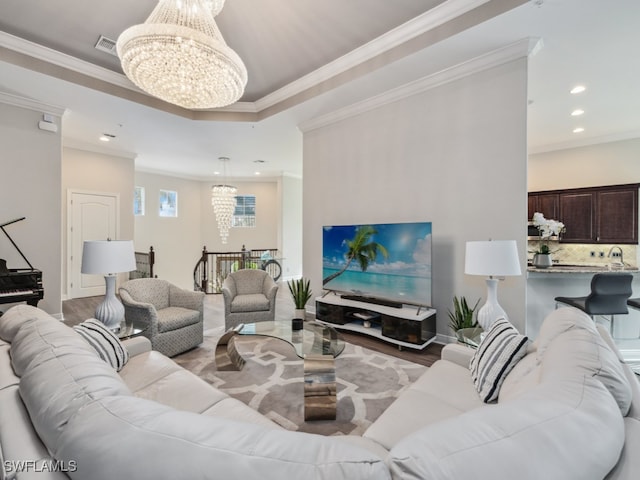 living room featuring an inviting chandelier, ornamental molding, and hardwood / wood-style flooring