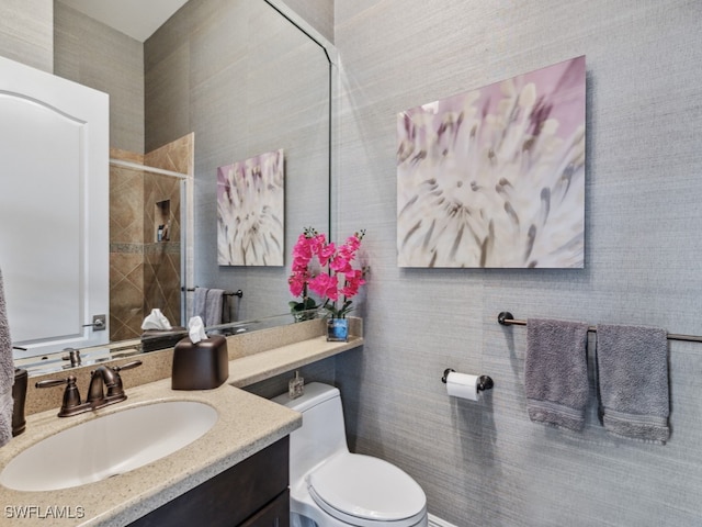 bathroom featuring vanity, toilet, and an enclosed shower