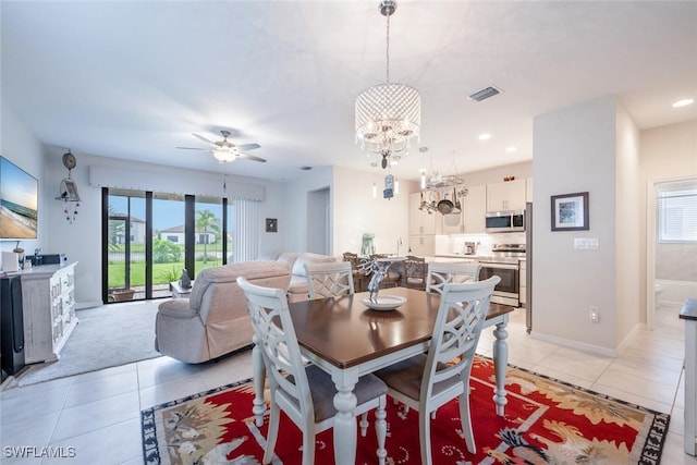 dining room featuring ceiling fan with notable chandelier and light tile patterned floors