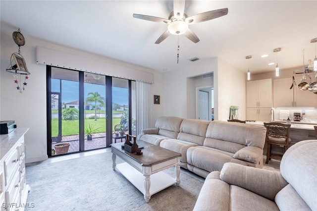 carpeted living room featuring ceiling fan