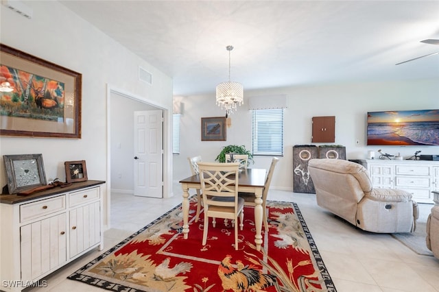 dining area with light tile patterned flooring and ceiling fan with notable chandelier