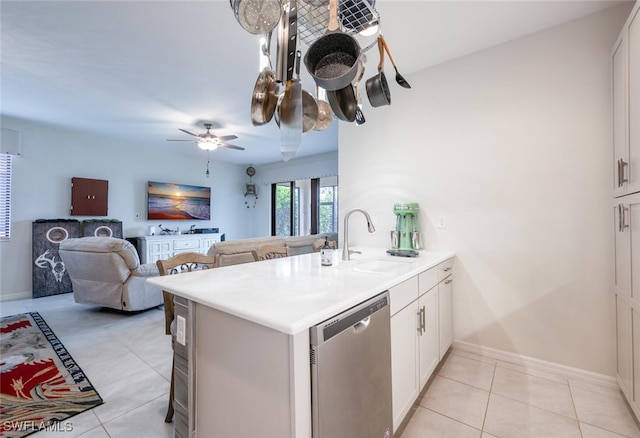 kitchen featuring dishwasher, light tile patterned floors, kitchen peninsula, and white cabinets