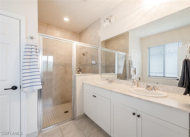 bathroom featuring tile patterned flooring, vanity, and a shower with shower door