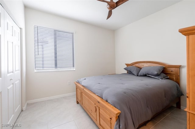 bedroom with light tile patterned floors, a closet, and ceiling fan