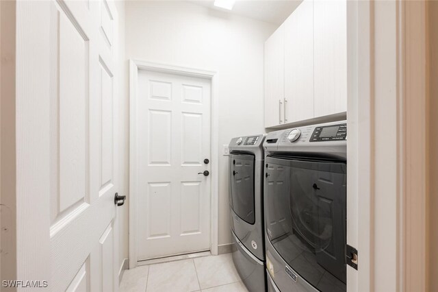 laundry room featuring cabinets, independent washer and dryer, and light tile patterned floors