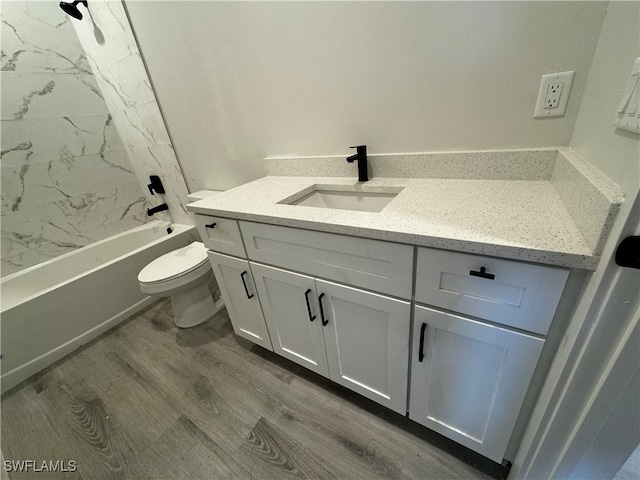 full bathroom featuring tiled shower / bath, vanity, toilet, and wood-type flooring