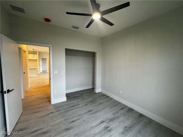 unfurnished bedroom with light wood-type flooring and ceiling fan