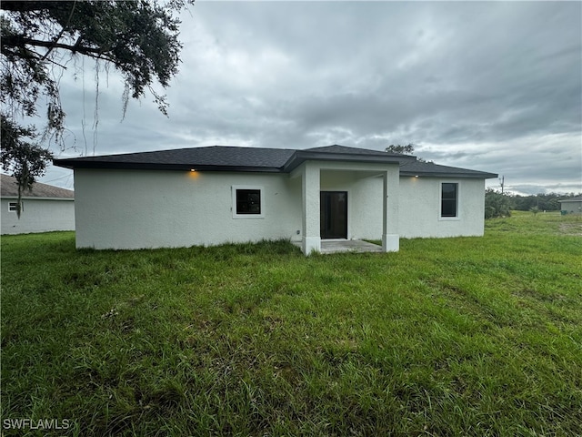 rear view of house featuring a lawn