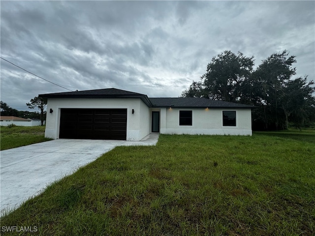 single story home featuring a garage and a front yard