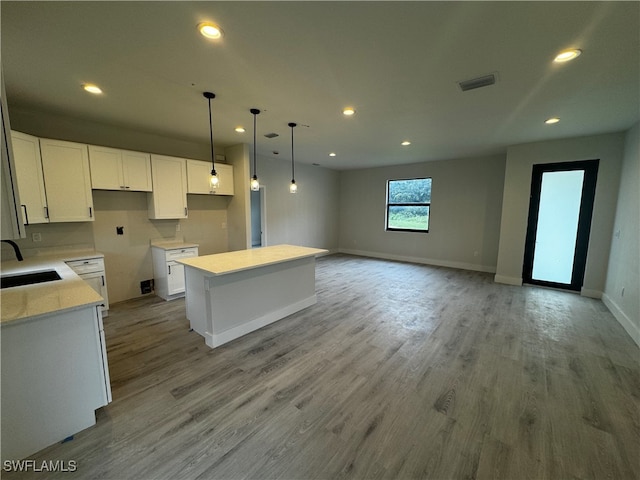 kitchen with light hardwood / wood-style flooring, a center island, and white cabinetry