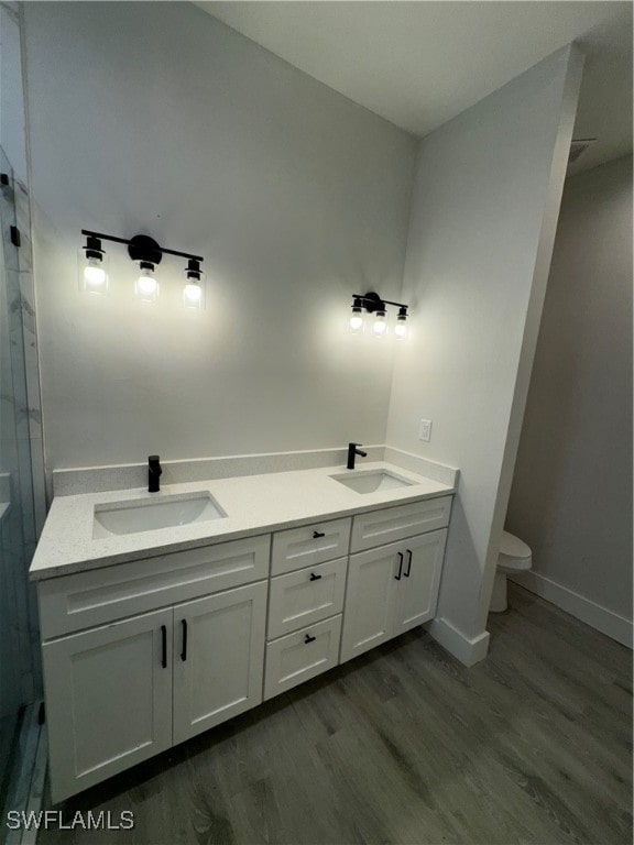 bathroom with hardwood / wood-style floors, vanity, and toilet