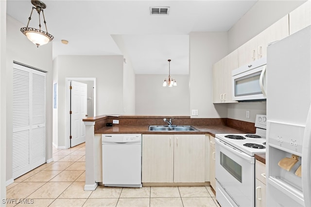 kitchen featuring white appliances, hanging light fixtures, sink, and light tile patterned floors