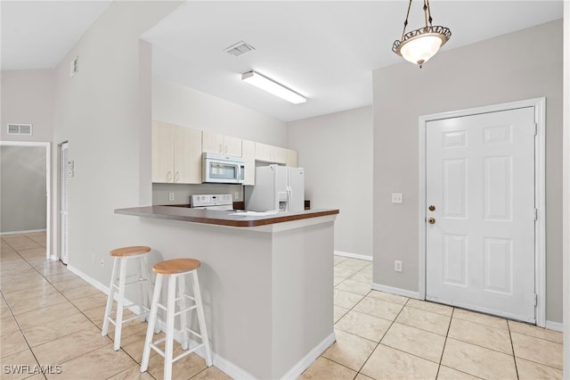 kitchen featuring a breakfast bar, white appliances, light tile patterned flooring, kitchen peninsula, and pendant lighting