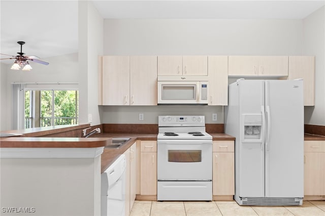 kitchen featuring light tile patterned flooring, kitchen peninsula, vaulted ceiling, and white appliances