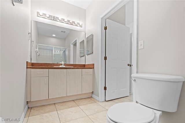 bathroom featuring walk in shower, tile patterned floors, vanity, and toilet