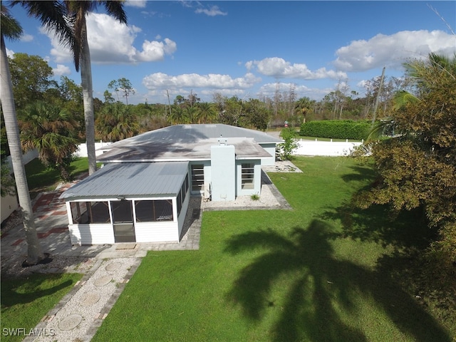 rear view of house with a sunroom and a yard