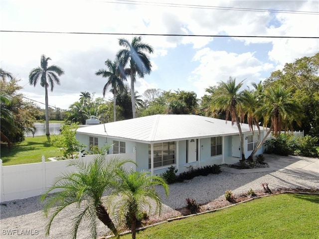 ranch-style house featuring a front yard and a water view