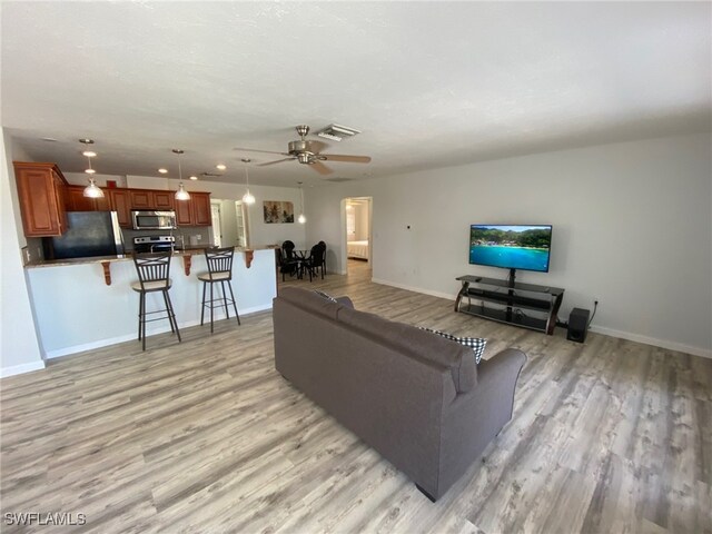 living room featuring light hardwood / wood-style floors and ceiling fan