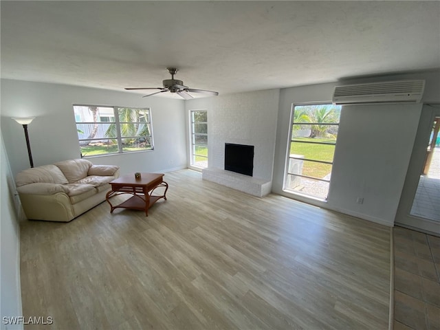 22 Constitution Dr, Naples, FL 34112 - living room with light wood finished floors, baseboards, a wall unit AC, and a healthy amount of sunlight