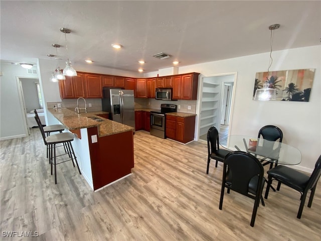 22 Constitution Dr, Naples, FL 34112 - kitchen with visible vents, a sink, a peninsula, a kitchen bar, and appliances with stainless steel finishes