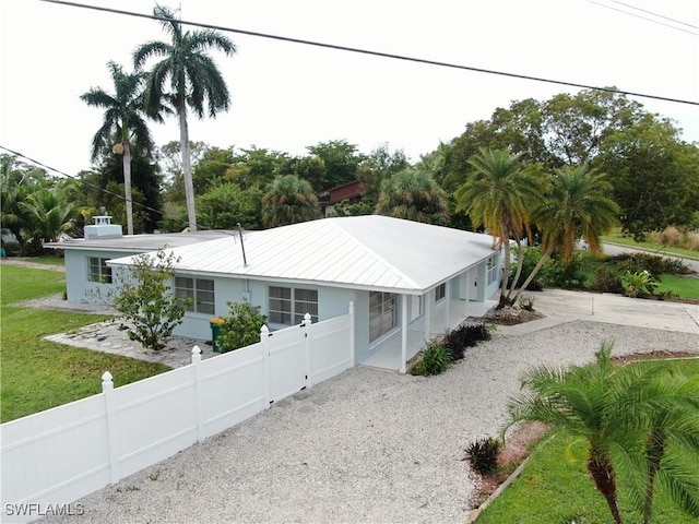 22 Constitution Dr, Naples, FL 34112 - view of front facade featuring fence private yard, gravel driveway, and stucco siding