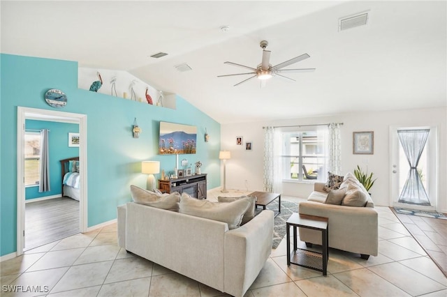 living room featuring vaulted ceiling, light tile patterned floors, a ceiling fan, and visible vents