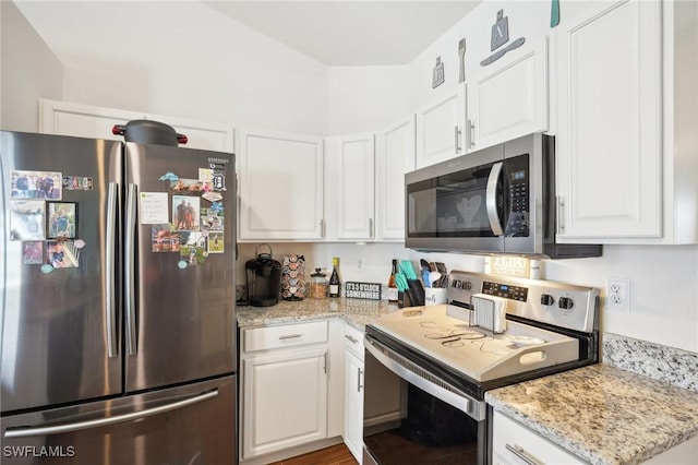 kitchen with light stone counters, white cabinets, and stainless steel appliances