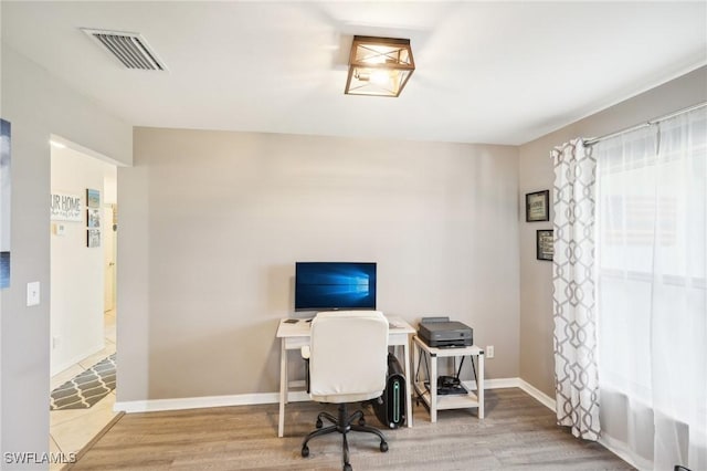 office area featuring visible vents, baseboards, and wood finished floors