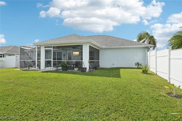 rear view of house featuring a yard, a fenced backyard, stucco siding, and a sunroom