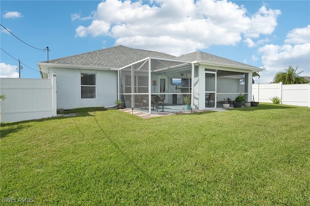 back of house featuring stucco siding, a lawn, a fenced backyard, and a shingled roof