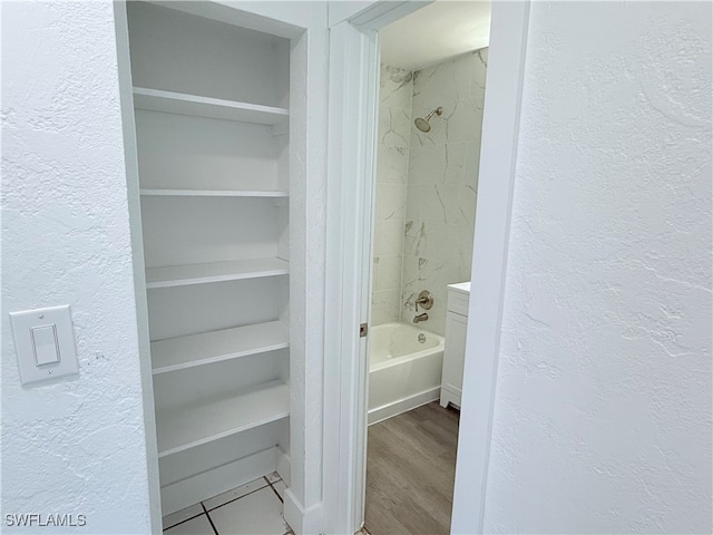 bathroom featuring hardwood / wood-style floors and tiled shower / bath