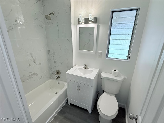 full bathroom featuring hardwood / wood-style floors, tiled shower / bath, toilet, and vanity