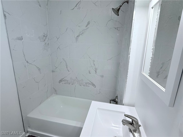 bathroom featuring tiled shower / bath combo and vanity