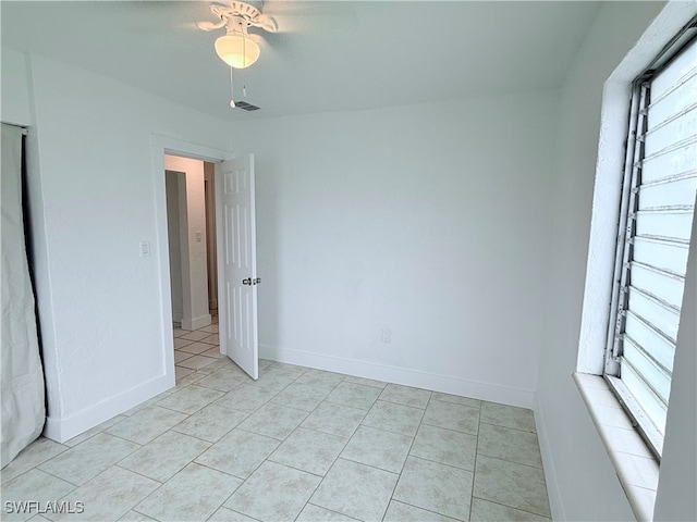 unfurnished room featuring light tile patterned floors, ceiling fan, and plenty of natural light