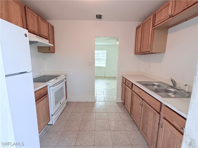 kitchen featuring white appliances, sink, and light tile patterned floors